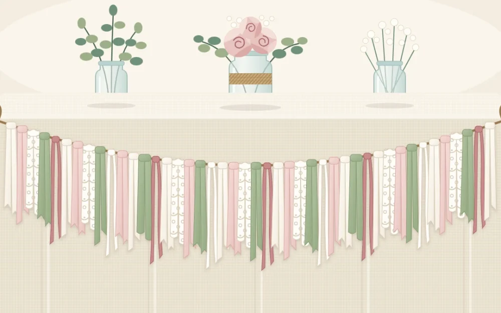 A full fabric strip garland in ivory, blush and sage hanging in a gentle curve along the front edge of a linen-covered table