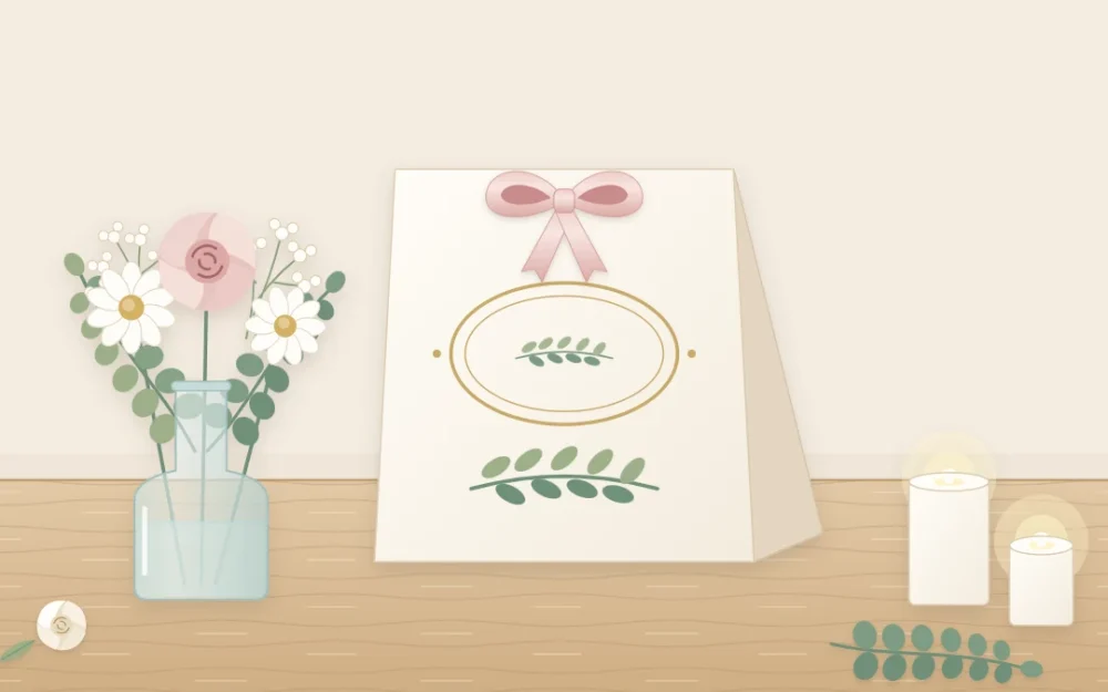 A folded ivory tent card on a table beside a small vase of flowers, decorated with a painted leaf sprig, a ribbon and a simple oval ornament