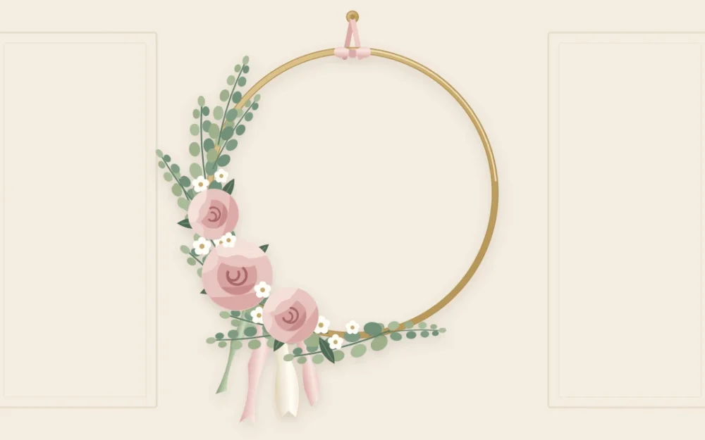 A gold hoop hanging from a ribbon, its lower left third covered with eucalyptus, blush roses and white flowers, ribbons trailing