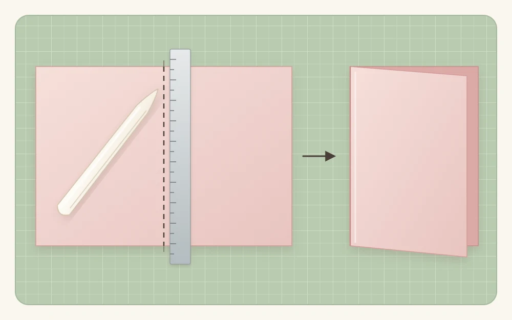 A flat cardstock rectangle with a dashed score line down the center and a bone folder on it, next to the folded card base