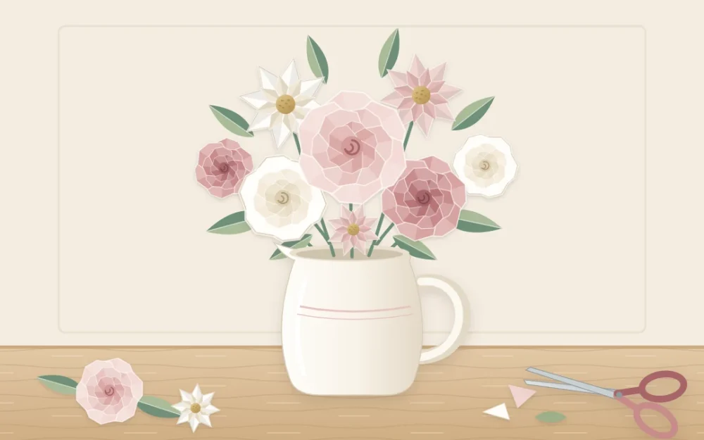A loose arrangement of cut and curled paper flowers in blush, ivory and dusty rose with paper leaves in a white jug