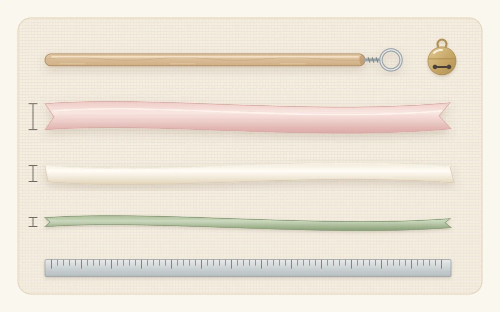 The parts of one wand laid flat: a wooden dowel with a metal screw eye at one end, three ribbons of different widths and a tiny bell