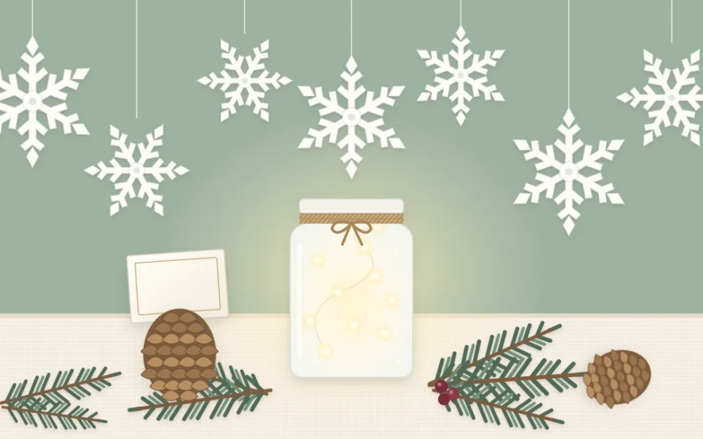 White paper snowflakes hanging above a frosted jar glowing with small lights, a pinecone holding a blank card and evergreen sprigs